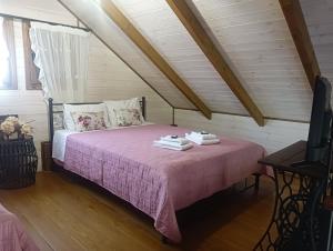 a bedroom with a pink bed in a attic at Chalet edelweiss preveza in Preveza