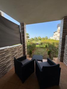 a screened in patio with two chairs and a large screen at Apartment for a family with pool AP13 in Saidia 