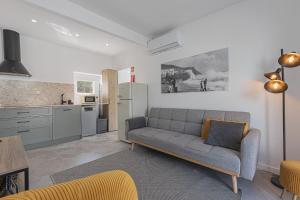 a living room with a couch and a kitchen at Casa Pinhão in Sesimbra