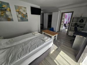 a bedroom with a large bed and a table at Central Urban Studio with Underground Parking in Târgu-Mureş