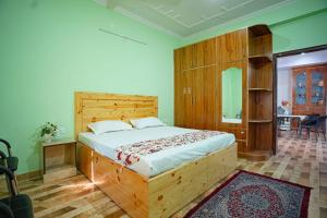 a bedroom with a wooden bed in a room at Riddhi Homestays Dharampur in Dharampur