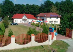 una valla frente a una casa con un edificio en Hotel Pod Dębami, en Pabianice