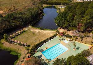uma vista aérea de uma piscina ao lado de um lago em Chalé Mississippi - Camping Carrion - ITU em Itu
