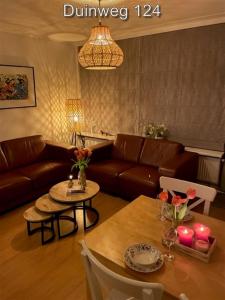una sala de estar con un sofá y una mesa en Appartementen Zuiderstrand H, en Westkapelle