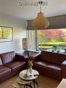 una sala de estar con un sofá y una mesa en Appartementen Zuiderstrand H, en Westkapelle