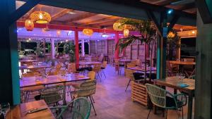 a restaurant with wooden tables and chairs and lights at VILLAS Lush Eden in Vieux-Habitants