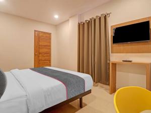 a bedroom with a bed and a desk and a television at Townhouse White Ridge KPHB OPP JNTU in Hyderabad +62 photos