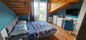 een kleine slaapkamer met een bed en een televisie bij Serce Kaszub pokoje z widokiem na Zatokę in Swarzewo