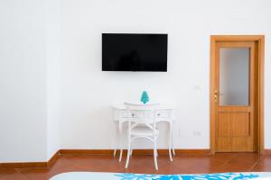 Biały stół i krzesło w pokoju z telewizorem w obiekcie Dipintodiblù w mieście Meta
