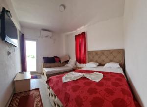 a bedroom with a red bed and a couch at Apartments Daris in Ulcinj