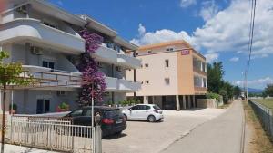 a building with cars parked in a parking lot at Apartments Daris in Ulcinj