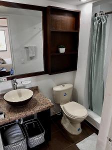 Un baño con inodoro, lavabo y espejo. en Apartamento en el Centro de San Andrés Islas con vista al mar- Edificio Bay Point 703, en San Andrés