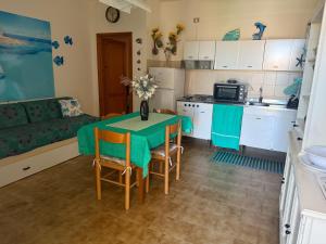 a kitchen and living room with a table and chairs at Baja SMERALDA in Stintino