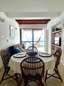 Una mesa de comedor con cuatro sillas y una habitación con ventana. en Apartamento en el Centro de San Andrés Islas con vista al mar- Edificio Bay Point 703, en San Andrés