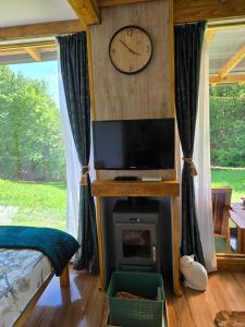 1 dormitorio con chimenea y reloj en la pared en Cabana Mura, 