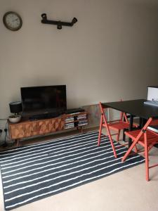 ein Wohnzimmer mit einem Tisch und einem Flachbildfernseher in der Unterkunft Quirky, romantic cottage with garden in Wye Valley in Ross on Wye + 19 Fotos