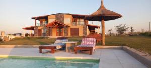 a house with a table and chairs next to a pool at Las Calandrias in La Cumbrecita