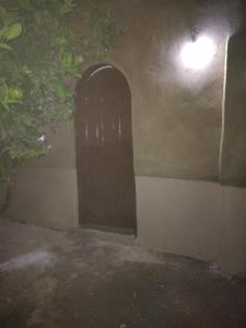 a door in the side of a house at night at Gateway to the stars camp&restarant in Al Aqālitah