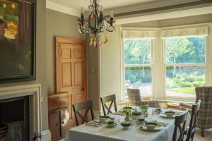 a dining room with a table and chairs and a fireplace at Outwood House in Leeds