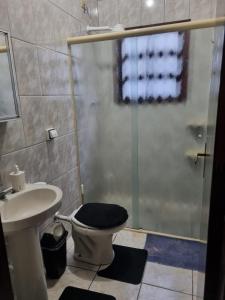 ein Badezimmer mit Dusche, Toilette und Waschbecken in der Unterkunft Casa completa a 300 mts da praia in Itanhaém + 15 Fotos