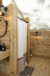 a shower curtain in a room with a wooden deck at Timberline Glamping Orange Beach in Gulf Shores