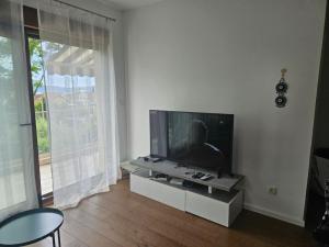 a living room with a flat screen tv on a table at Lazure apartment in Tivat
