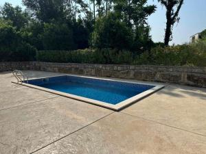 a swimming pool in a patio with a stone wall at Lazure apartment in Tivat
