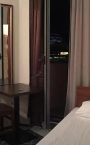 a bedroom with a bed and a table and a window at Apartment VRIS in Tsarevo