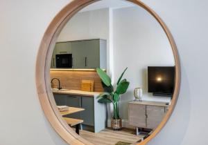 ein Spiegel, der eine Küche mit Spüle und Schreibtisch widerspiegelt in der Unterkunft Arlington Apartments - City Centre Luxury Apartments in Glasgow