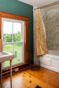 bagno con finestra, vasca e lavandino di Cozy Skiing Vacation in Historic 1800’s Colonial a Tinmouth Altre 59 foto