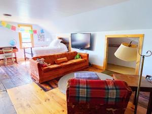 un soggiorno con un divano e un letto di Cozy Skiing Vacation in Historic 1800’s Colonial a Tinmouth