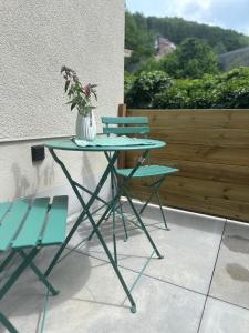 a table with two chairs and a vase with flowers at EifelQuartier L2 in Schleiden