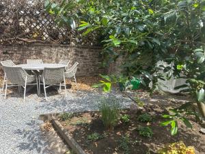 a table and chairs in a garden with a tree at EifelQuartier L2 in Schleiden +23 photos