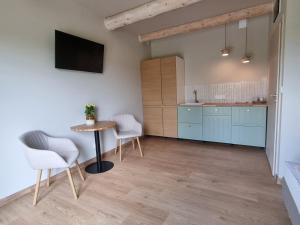 a kitchen with blue cabinets and a table and chairs at Szept Gór in Lutowiska