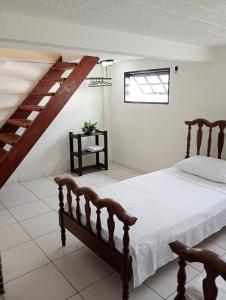 ein Schlafzimmer mit einem Bett und einer Treppe in der Unterkunft Casa perto da praia em Mosqueiro-PA in Belém