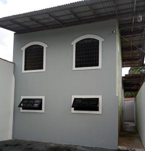 ein weißes Gebäude mit drei Fenstern in der Unterkunft Casa perto da praia em Mosqueiro-PA in Belém