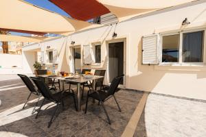 a dining room with a table and chairs on a patio at Villa Memories in Kineta