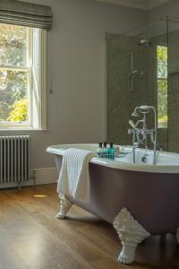 a bath tub in a bathroom with a window at Outwood House in Leeds +40 photos
