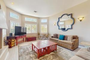 een woonkamer met een bank en een flatscreen-tv bij La Quinta Vacation Pool Home in La Quinta