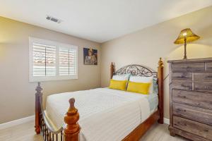 een slaapkamer met een bed, een dressoir en een raam bij La Quinta Vacation Pool Home in La Quinta +23 foto's