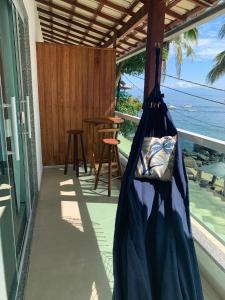 a hammock on a balcony with a view of the ocean at Carneiro's House in Praia de Araçatiba