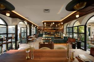 a restaurant with a table and chairs and windows at Tinspiro Alaçatı in Alaçatı