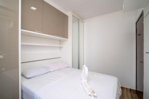 a small bedroom with a white bed and white cabinets at Rental Palhoça - Acomodações Residenciais IV in Palhoça