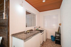 a kitchen with a sink and a counter with a mirror at Rental Palhoça - Acomodações Residenciais IV in Palhoça +80 photos