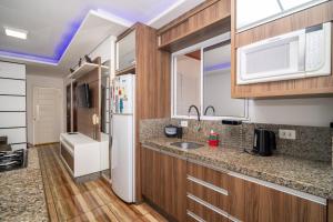 a kitchen with a sink and a refrigerator at Rental Palhoça - Acomodações Residenciais IV in Palhoça