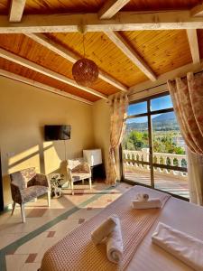 Un dormitorio con una cama y una ventana grande. en Blen Grand, en Berat