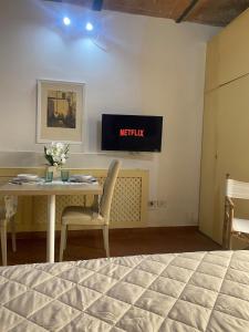 a room with a table and a television on the wall at Il Giardino di Barbara in Prato +9 photos