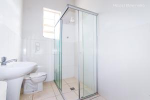 a bathroom with a glass shower stall next to a toilet at Hostel Mineirinho in Belo Horizonte