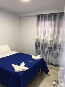 a bedroom with a blue bed with white flowers on it at Áncora Beach Hotel in Máncora