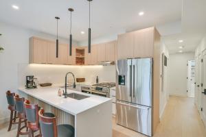 a kitchen with wooden cabinets and a stainless steel refrigerator at Near Biotechs and MIT Cozy Condo with Fireplace in Cambridge